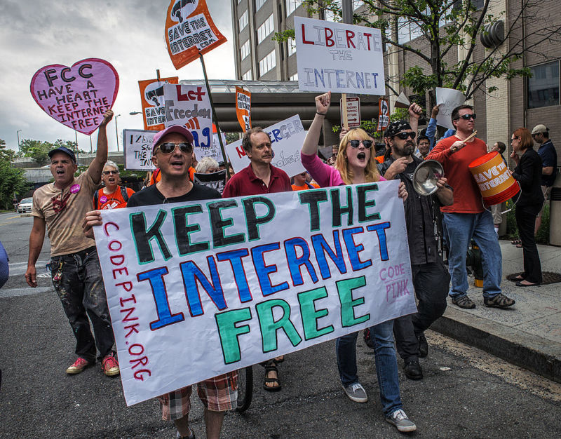 WASHINGTON, DC - MAY 15:
Protesters march past the FCC headquarters before the Commission meeting on net neutrality proposal on May, 15, 2014 in Washington, DC.
(Photo by Bill OLeary/The Washington Post via Getty Images)