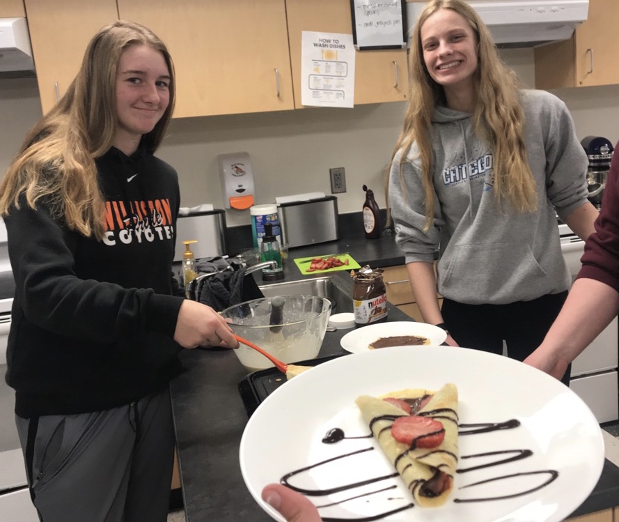 Chesni Strand (left) and Demi Perterson (right) making and serving crepes.